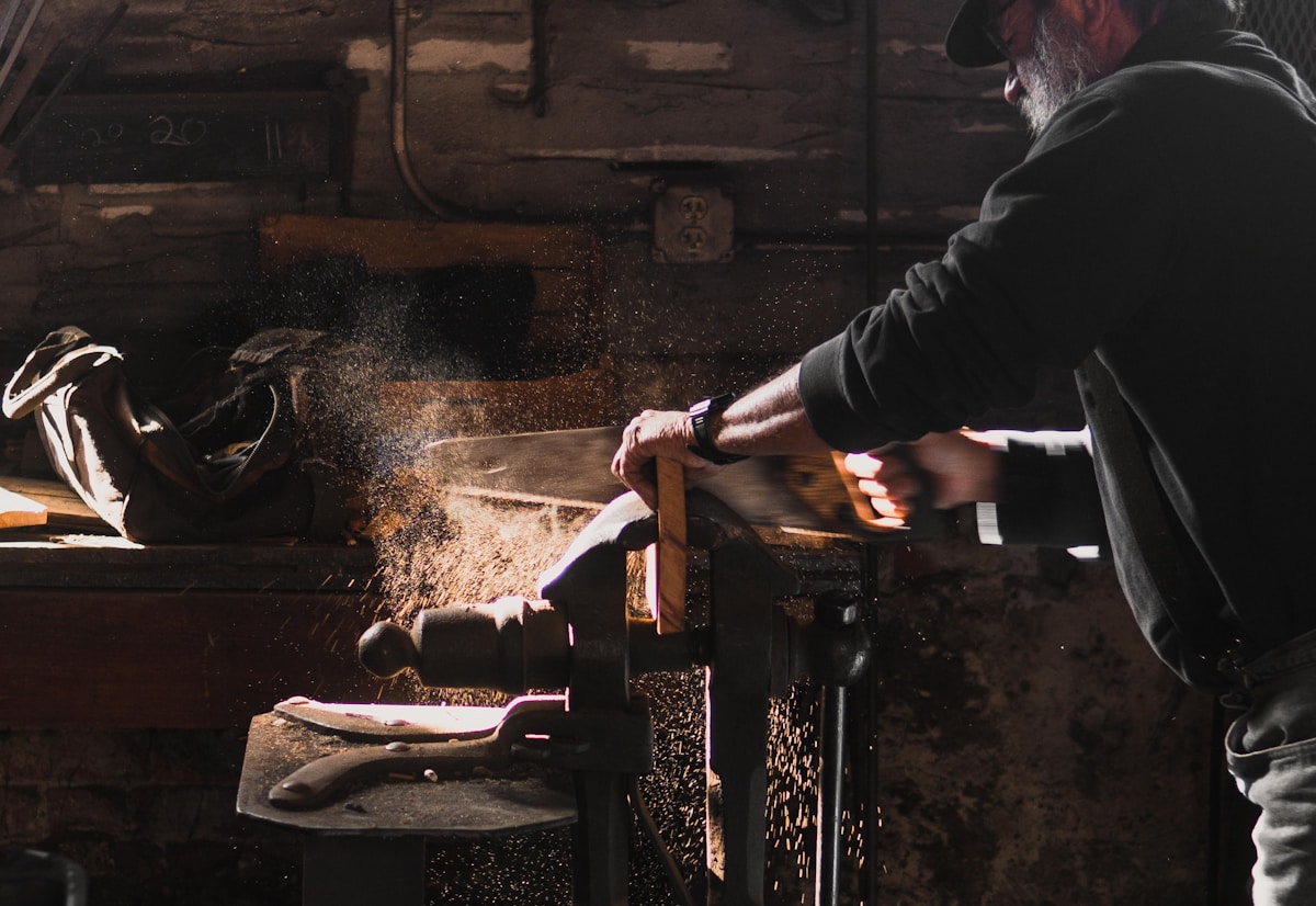 Carpenter sawing timber in the workshop