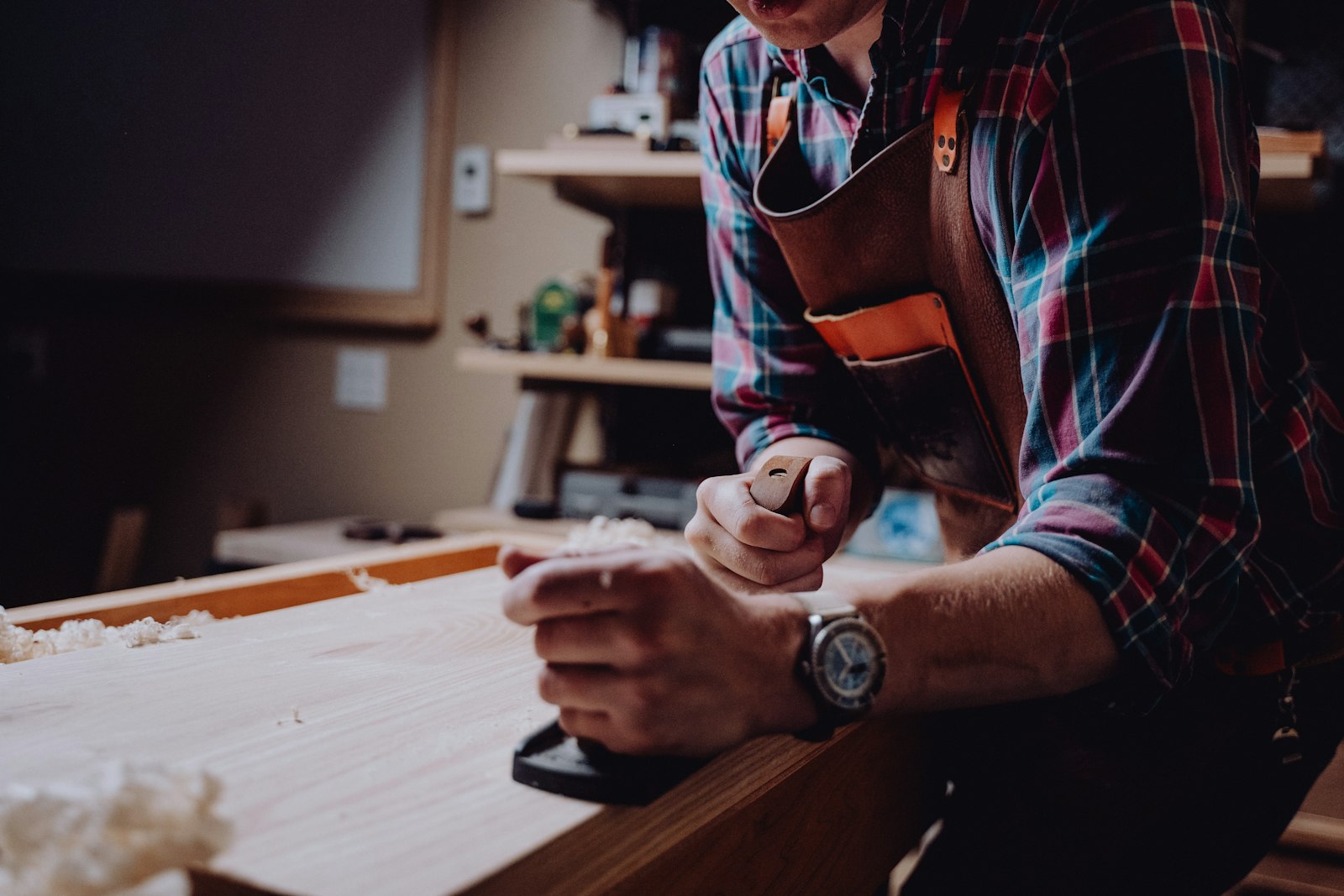 Carpenter hand-planing timber for custom joinery