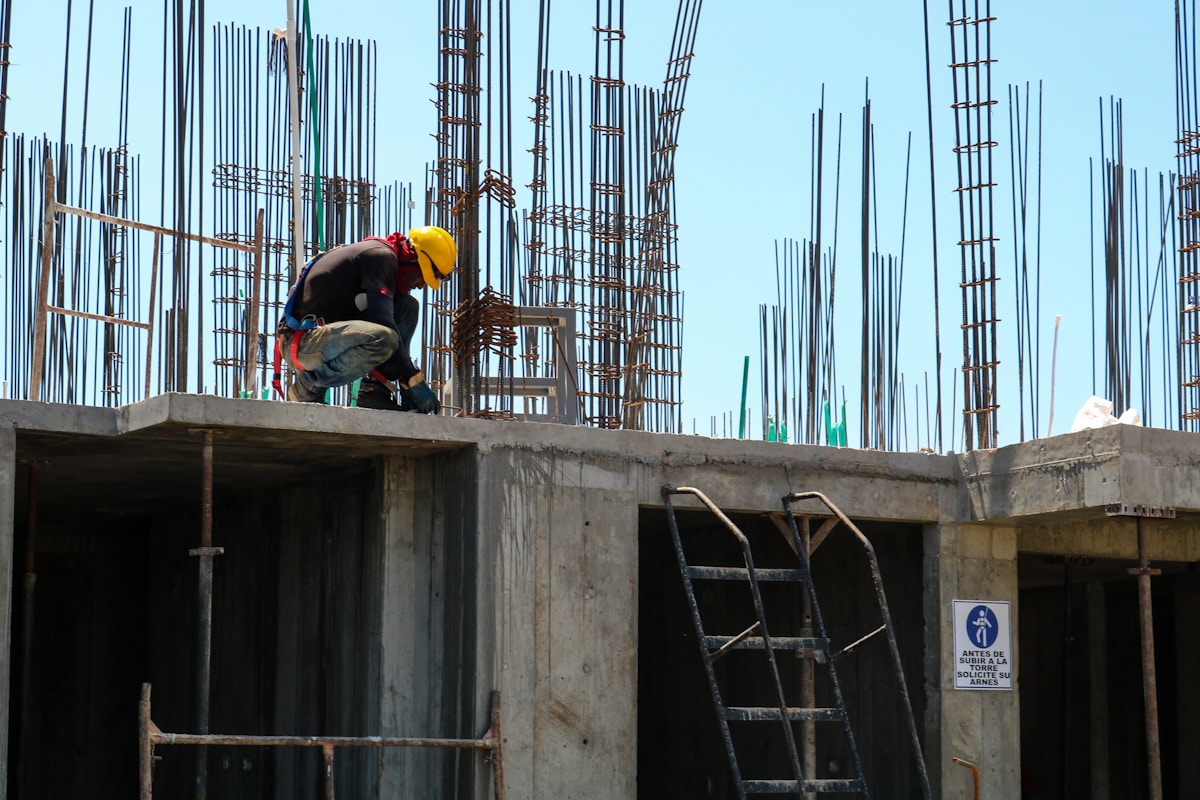 Tradesman kneeling on an unfinished building