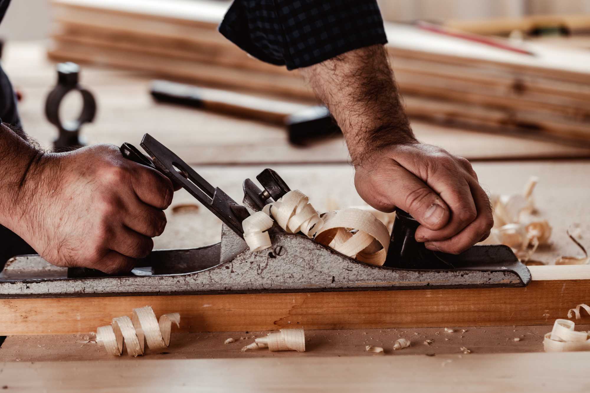 Carpenter hand-planing timber for custom joinery
